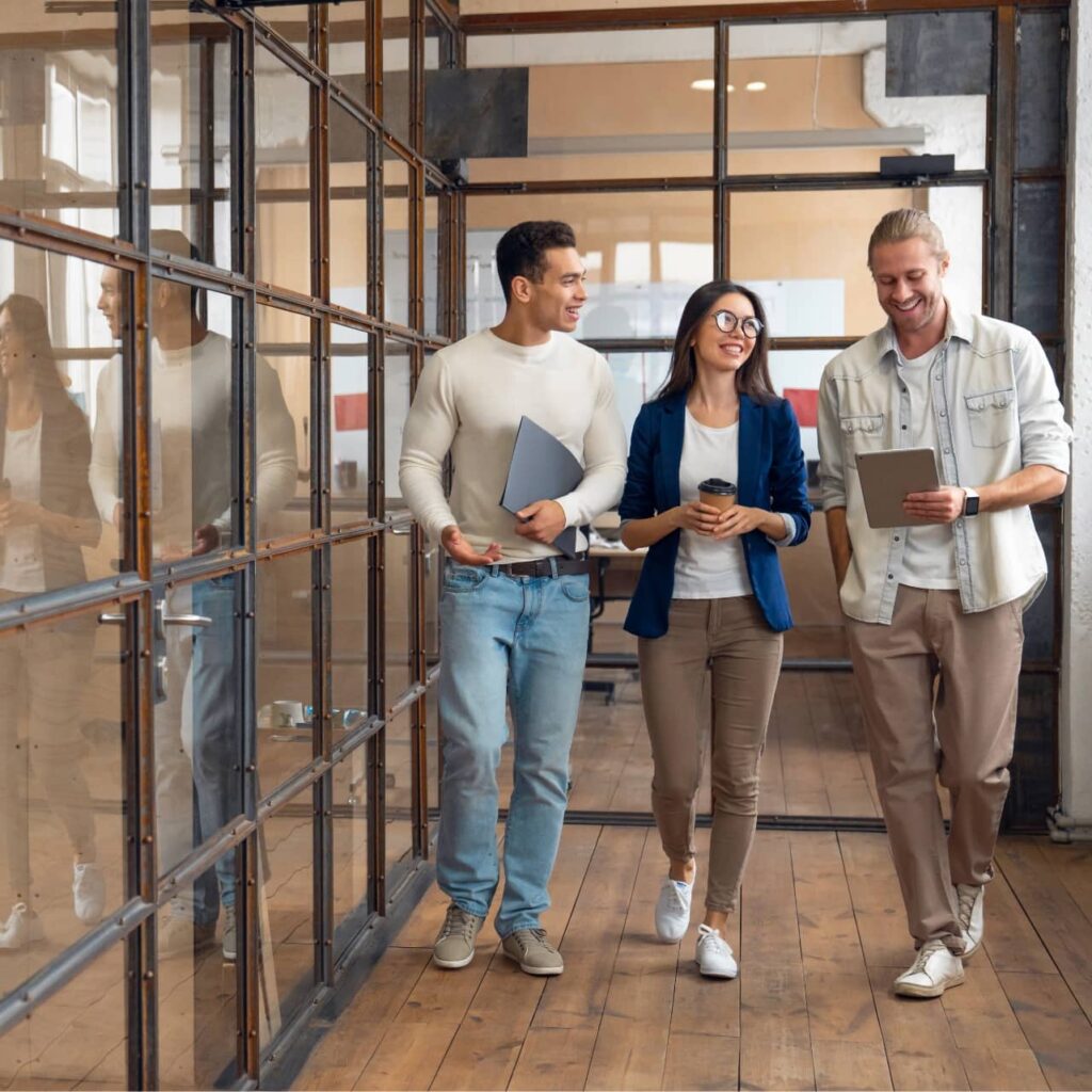 Group of people walking in office hallway.